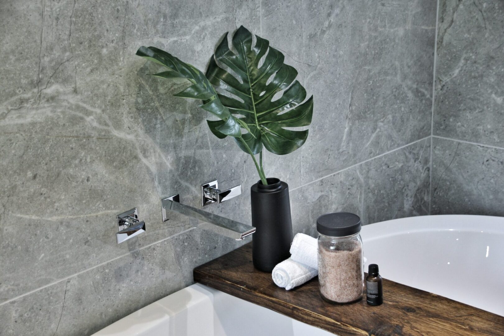 A bathroom with a plant in the corner of it